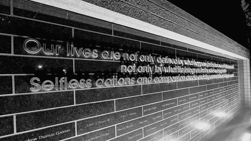 Low angle view of text on wall at night