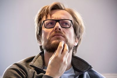 Portrait of mature man wearing eyeglasses against gray background