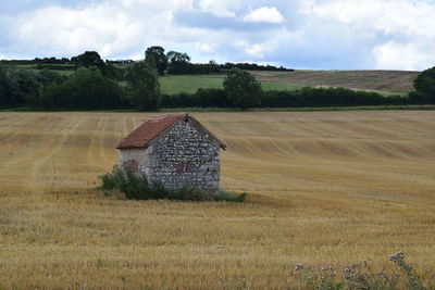 Hay bales on field against sky