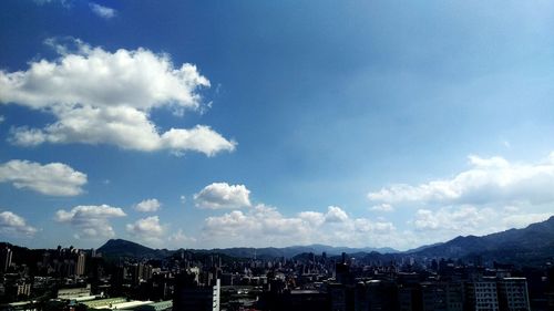 Cityscape against cloudy sky