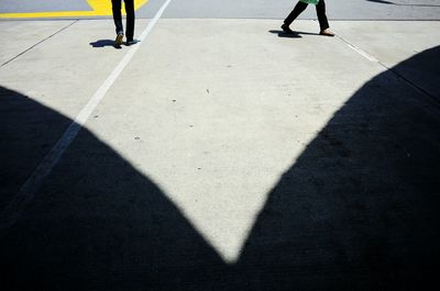 Low section of man with shadow on tiled floor