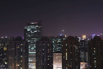 Illuminated buildings against sky at night