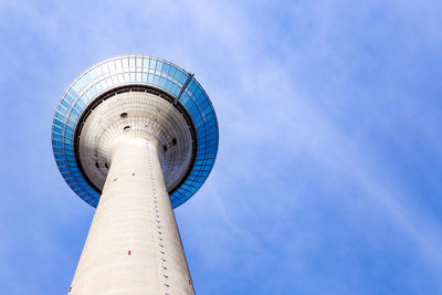 Low angle view of communications tower against blue sky