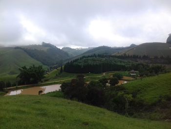 Scenic view of green landscape and mountains against sky