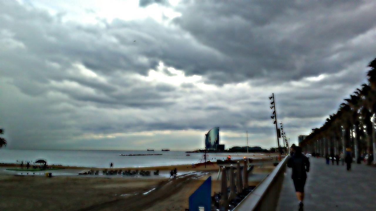 sky, cloud - sky, sea, water, beach, cloudy, weather, built structure, shore, horizon over water, cloud, architecture, sand, incidental people, overcast, dusk, nature, railing, pier, building exterior