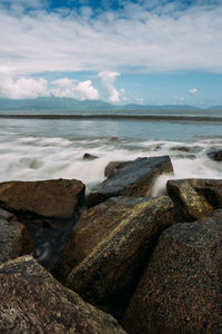 Rocks on beach against sky