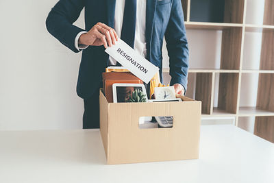 Midsection of man holding umbrella in box