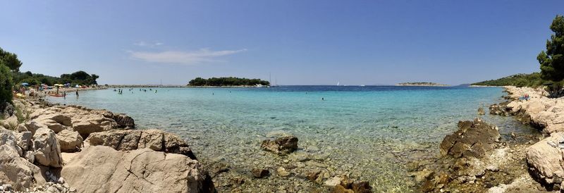 Scenic view of sea against sky with small island in the background