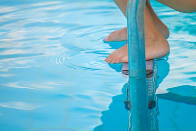 Low section of person swimming in pool