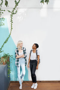 Side view of woman standing against wall