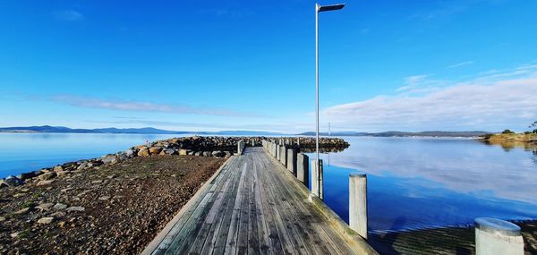 Pier over sea against blue sky