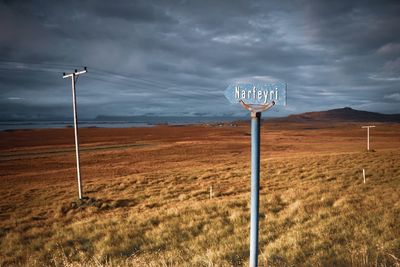 Wind turbines on field against sky