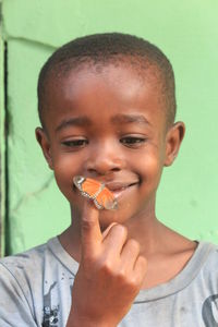 Smiling boy with butterfly on finger