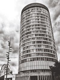 Low angle view of modern building against cloudy sky