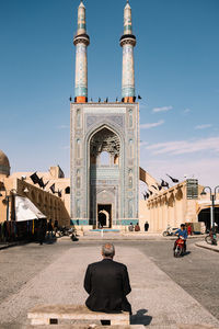 Rear view of people at temple against sky