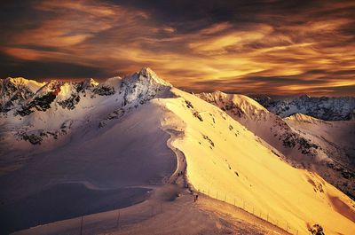 Scenic view of snowcapped mountains against sky during sunset