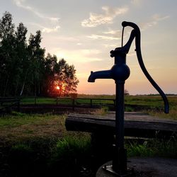 Built structure on field against sky during sunset