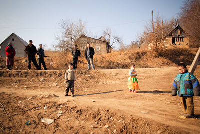 Group of children playing on land against sky