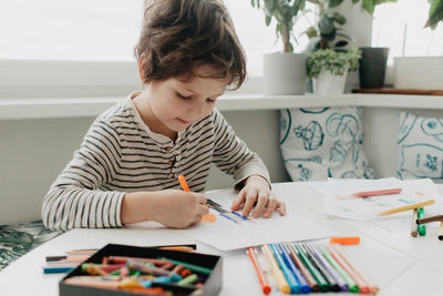 The boy draws with felt-tip pens. high quality photo