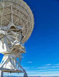 Low angle view of communications tower against clear blue sky