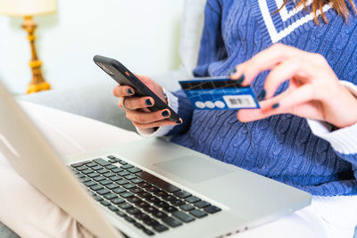 Midsection of woman using mobile phone