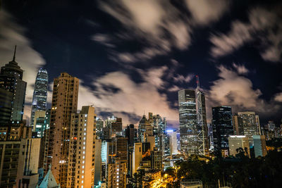 Illuminated buildings in city against sky at night