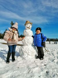 Full length of children on snow covered land