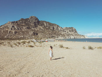 People on beach against clear sky