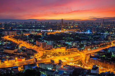 High angle view of illuminated city against sky at sunset