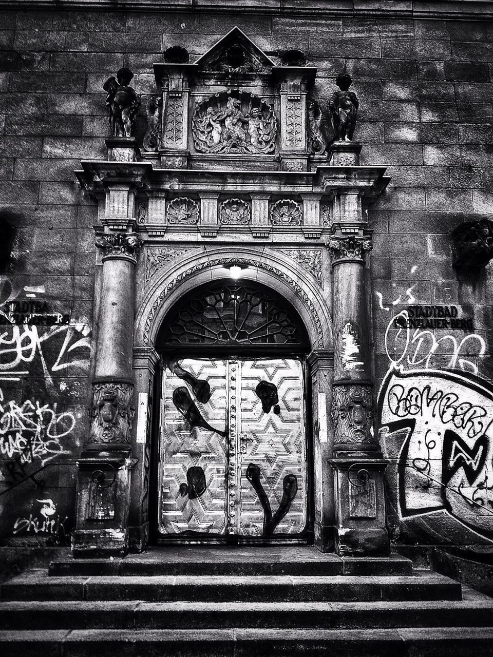 architecture, built structure, building exterior, art and craft, art, entrance, creativity, door, text, human representation, gate, graffiti, wall - building feature, facade, arch, old, outdoors, ornate, closed, day