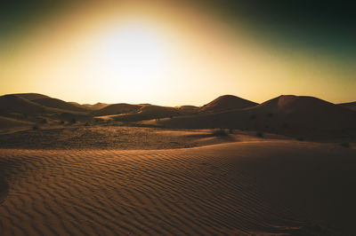 Scenic view of desert against sky during sunset