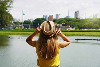 Back view of traveler girl enjoying skyline of sao paulo metropolis from ibirapuera park, brazil.