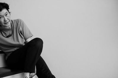 Portrait of mature woman sitting against white background