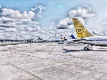 Airplane on airport runway against sky