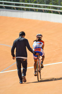 Rear view of men riding bicycle