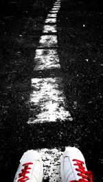 Low section of man standing on road