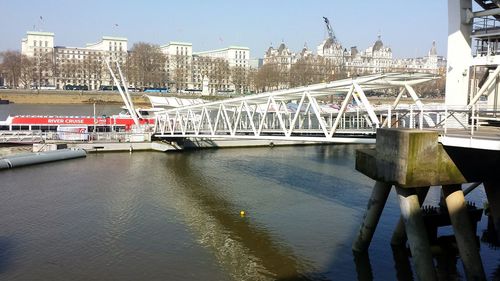 Bridge over river in city against clear sky