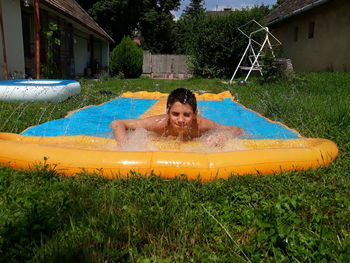 Boy enjoying on inflatable tub at yard