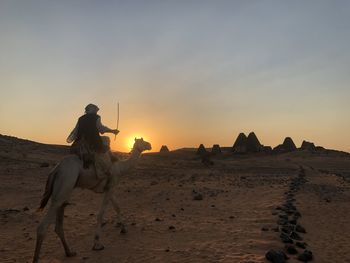 Riding camelback in the desert on the way to the pyramids of meroe