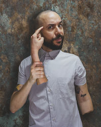 Portrait of young man standing against wall