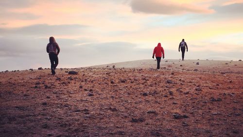 People walking on beach against sky