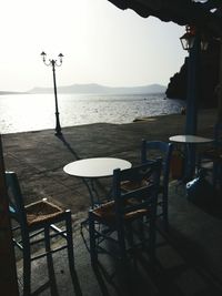 Empty chairs and tables at seaside