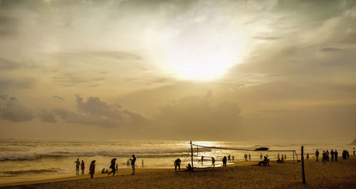 Silhouette people at beach during sunset