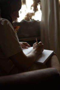 Side view of woman using laptop at home