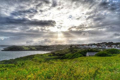 Scenic view of landscape by sea against sky