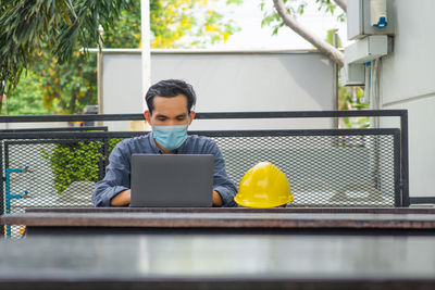 Man using mobile phone while sitting on table