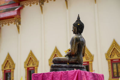 Statue outside temple against building