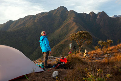 Full length of man standing on mountain against sky