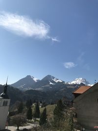 Houses on snowcapped mountain against sky