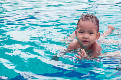 Portrait of cute boy swimming in pool